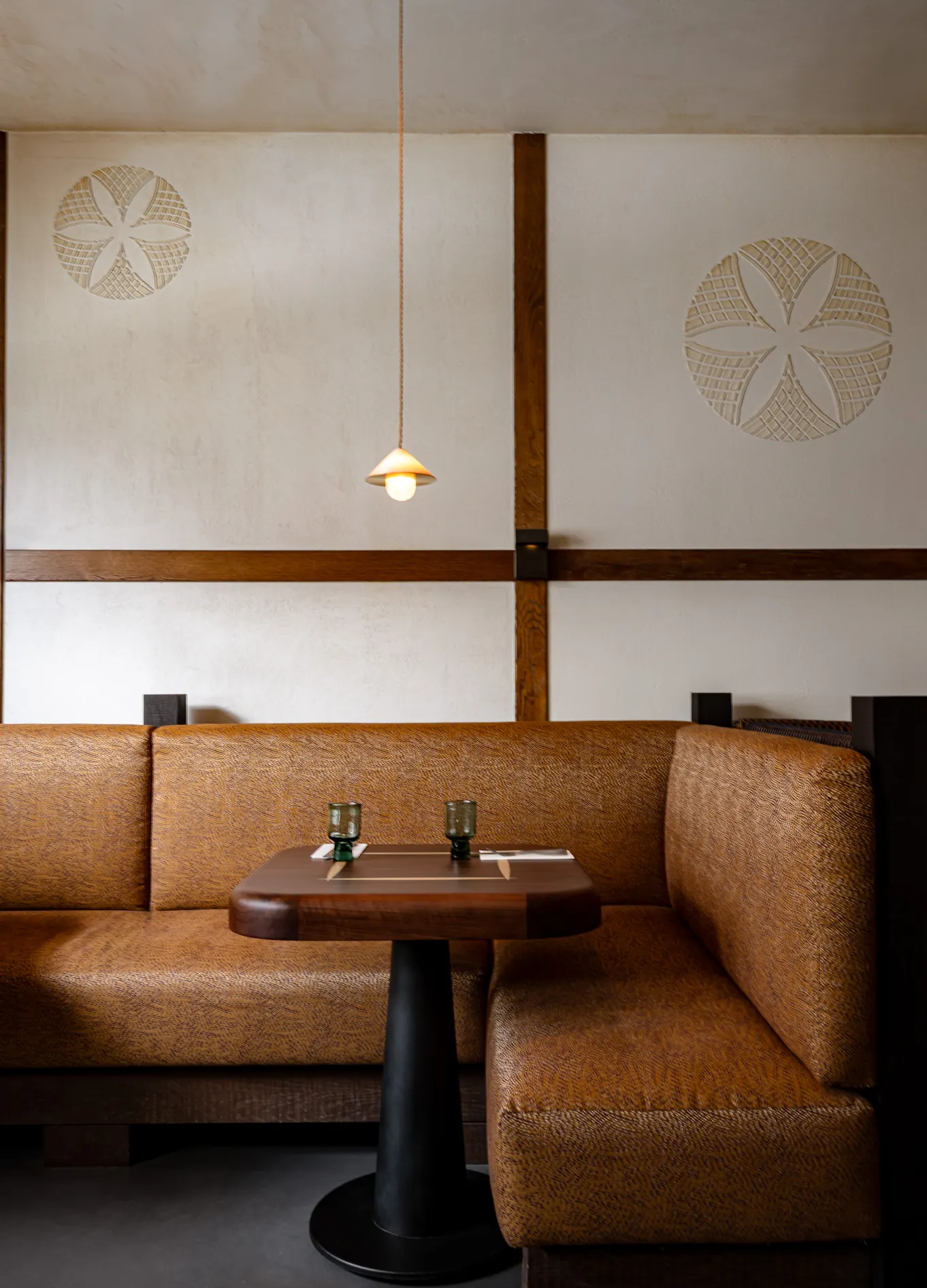 Sala de jantar intimista com bancos em pele no restaurante de alta gastronomia L’Aiglon, Val d’Isère.