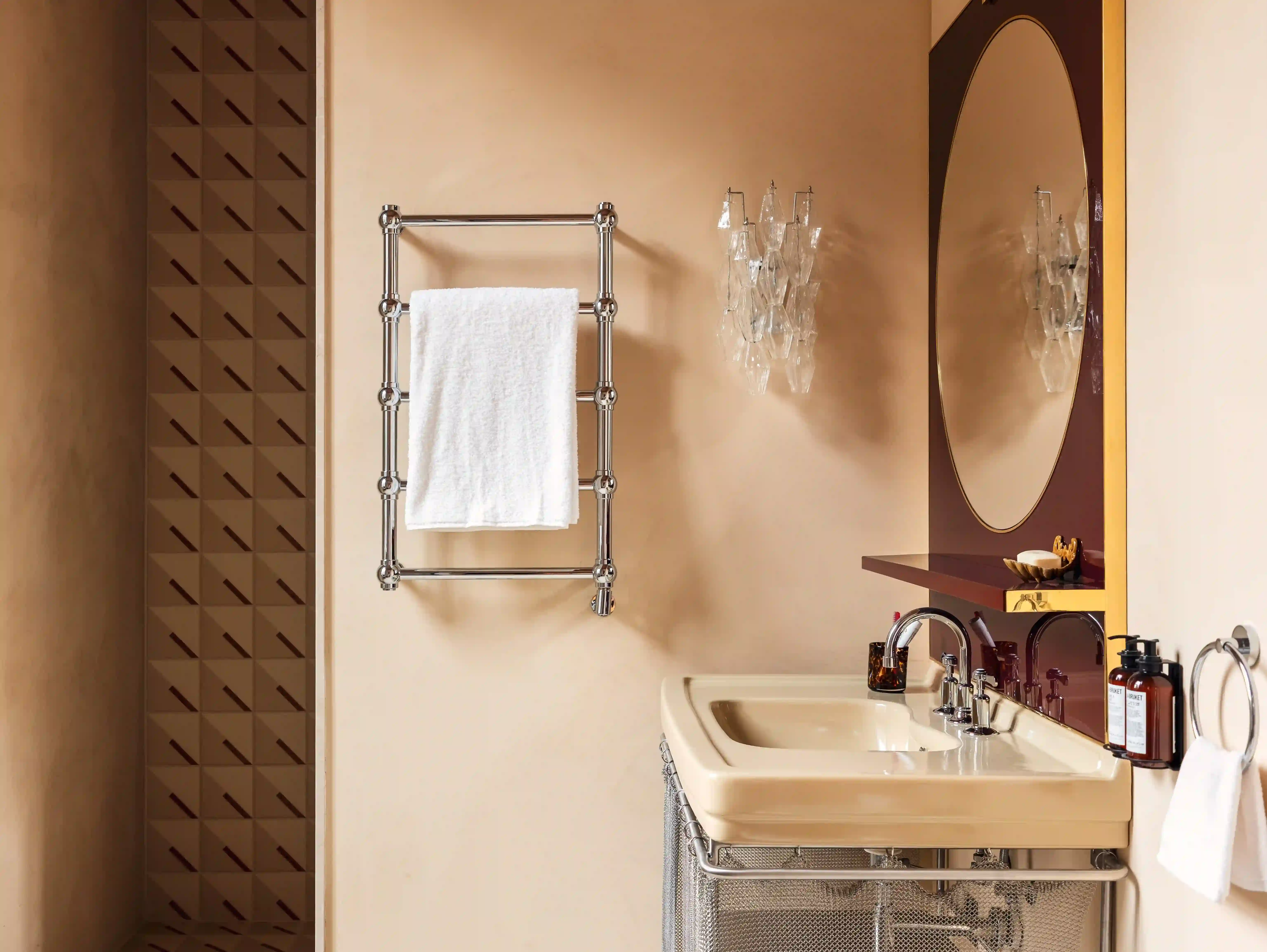 Salle de bains moderne avec meuble-lavabo, miroir ovale et sèche-serviettes chromé.