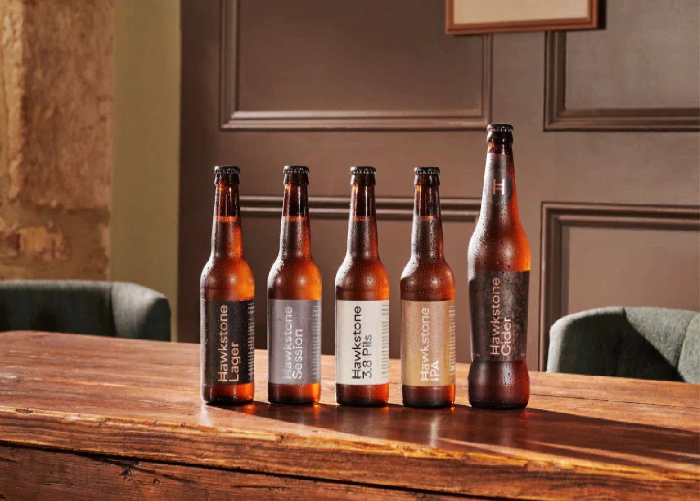 Botellas de cerveza artesanal expuestas sobre una barra de madera