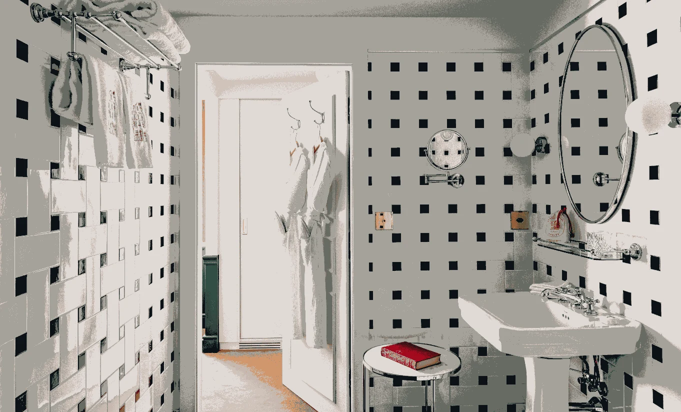 Chic bathroom with black and white square-patterned tiles, pedestal sink, and hanging bathrobes.