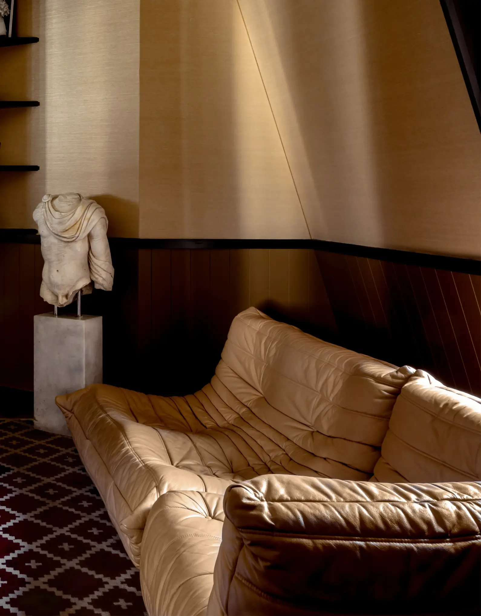 Sofá confortável num lounge ricamente decorado, que encarna o conforto e a elegância típicos do Grupo Experimental.