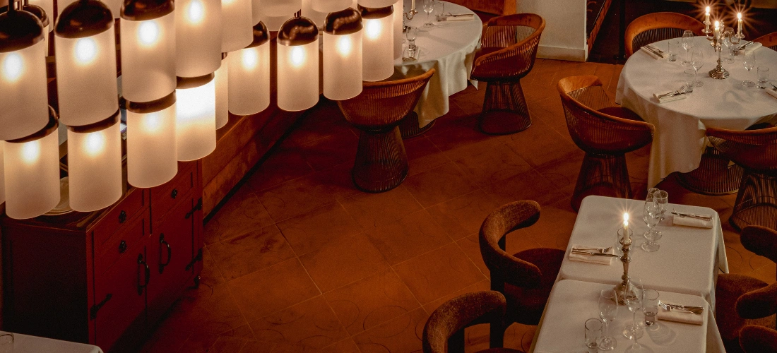 Intérieur élégant du restaurant Montesol Experimental avec éclairage tubulaire unique et tons chauds.