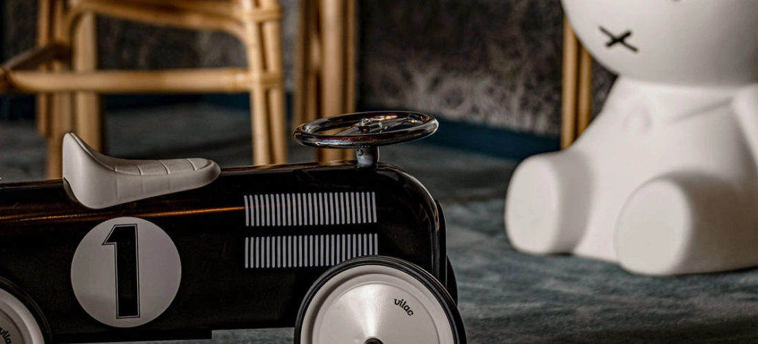Petite voiture à monter et lampe surdimensionnée en forme de lapin blanc dans l'aire de jeux pour enfants de l'Experimental Chalet Val d'Isère.