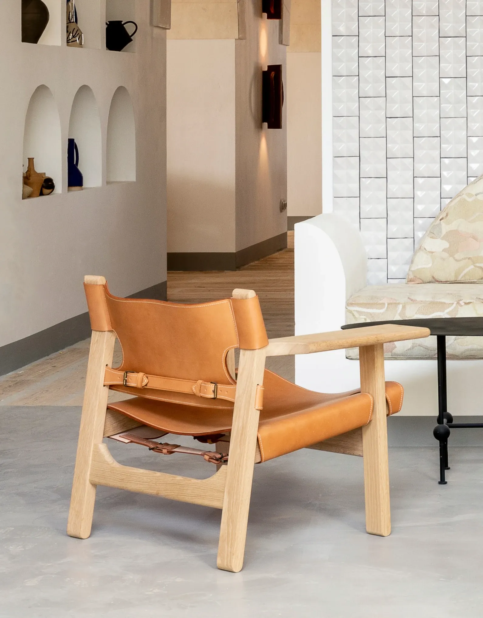 Un sillón de diseño en un salón elegante y luminoso, que refleja el esmero del Grupo Experimental en el diseño de interiores.