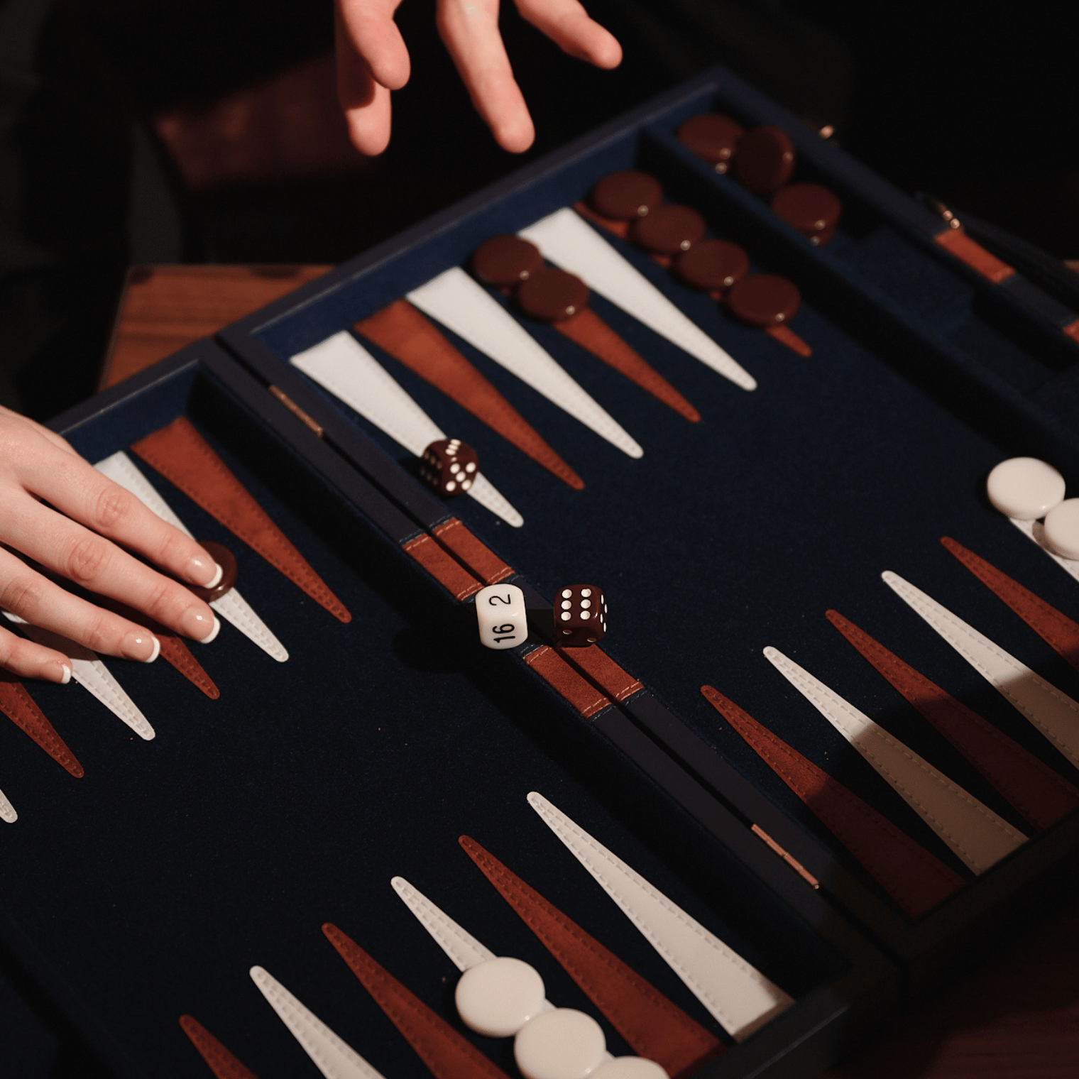 Hands over a backgammon board.