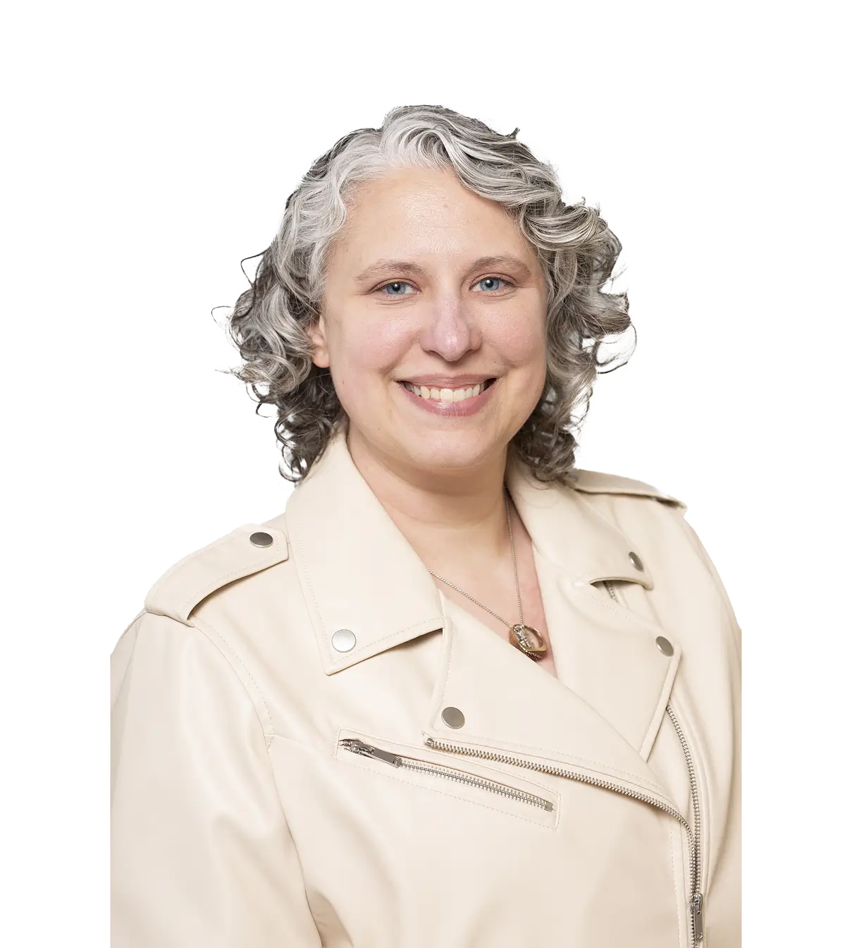 Smiling person with curly gray hair wearing a light beige jacket and a necklace.