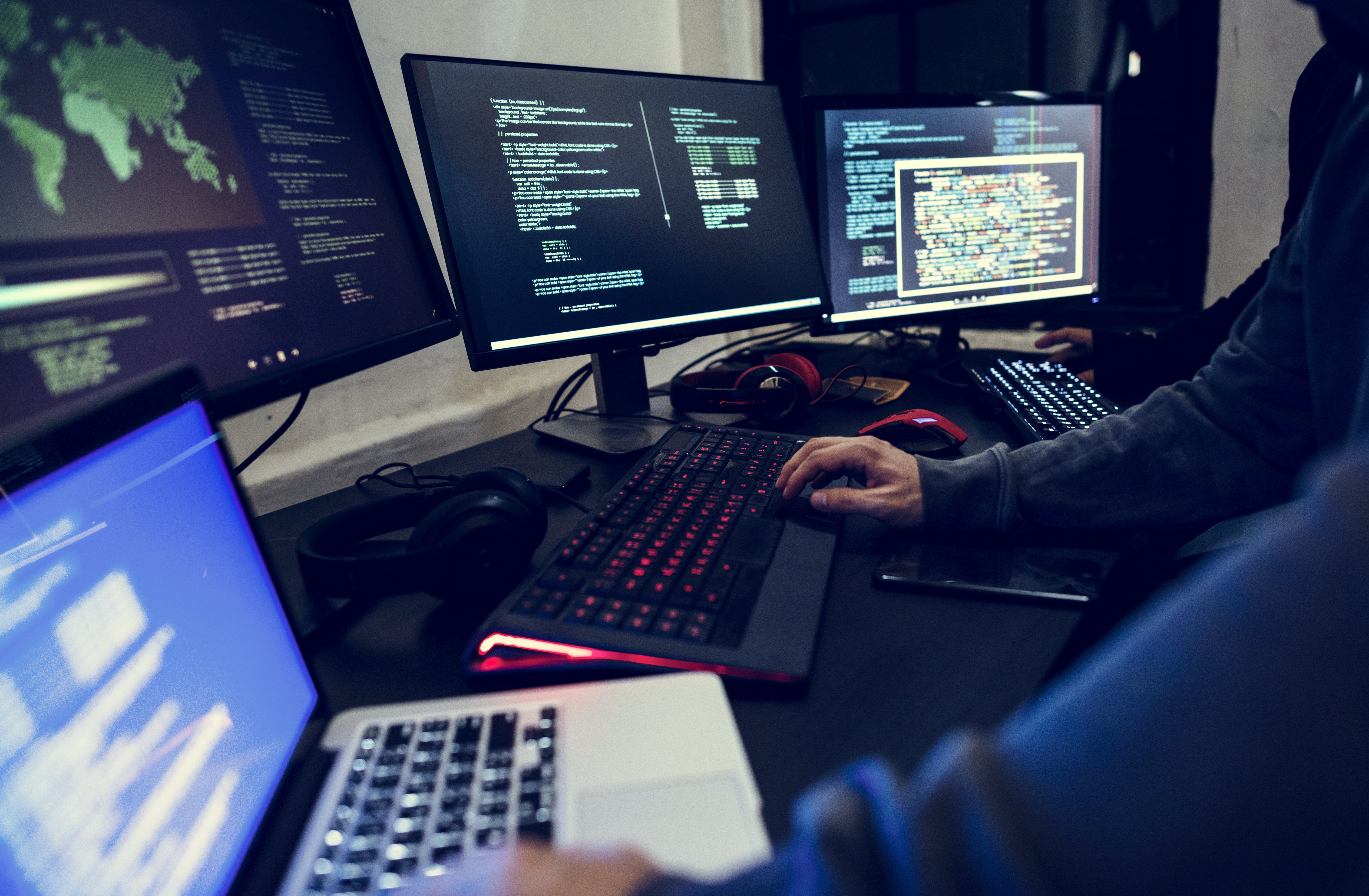 Professionisti della sicurezza informatica analizzano codice su più monitor, simbolo di cybersecurity, protezione dei dati, hacking etico e sicurezza digitale.