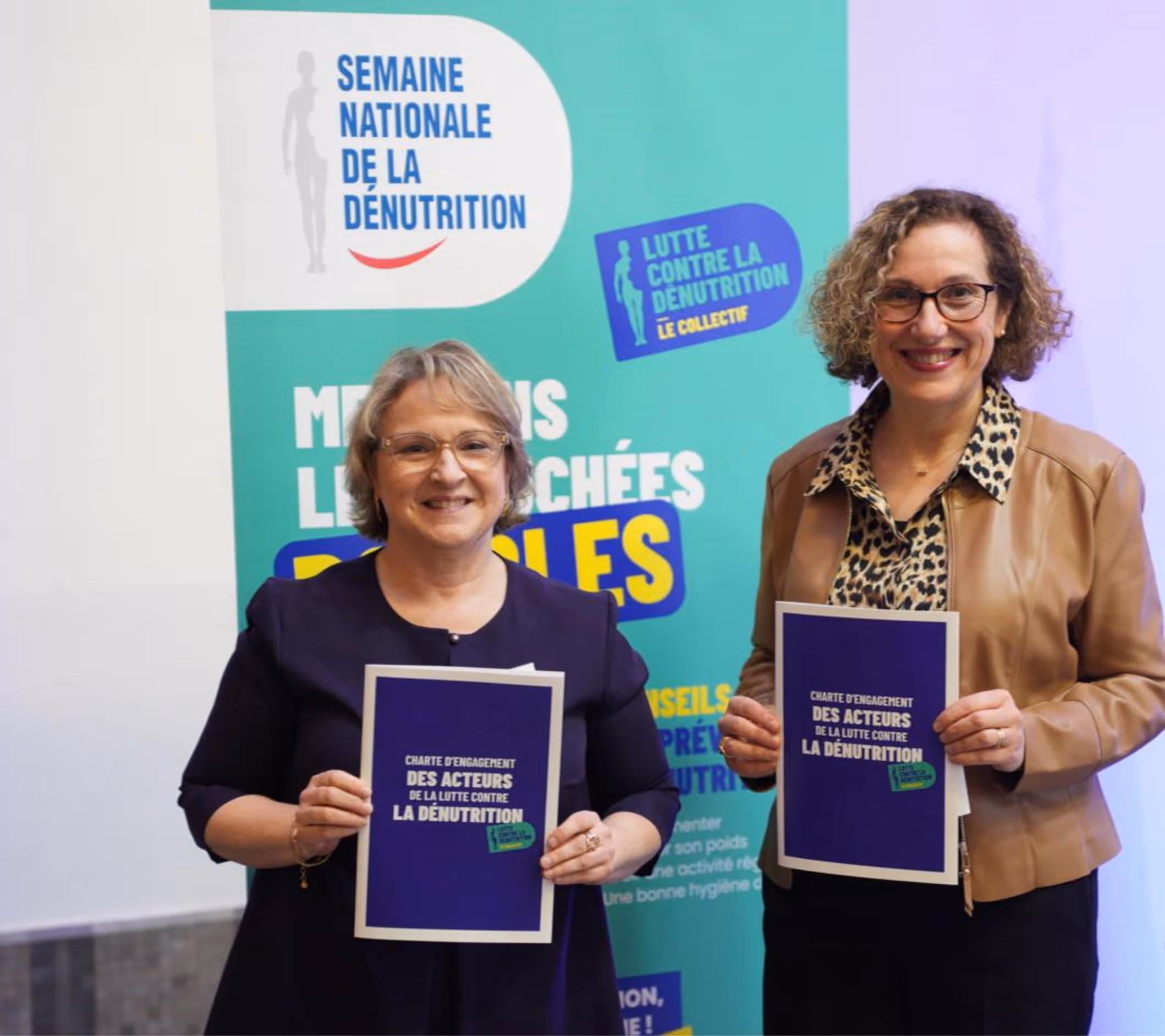 Deux femmes présentant la Charte d'engagement des acteurs de la lutte contre la dénutrition.
