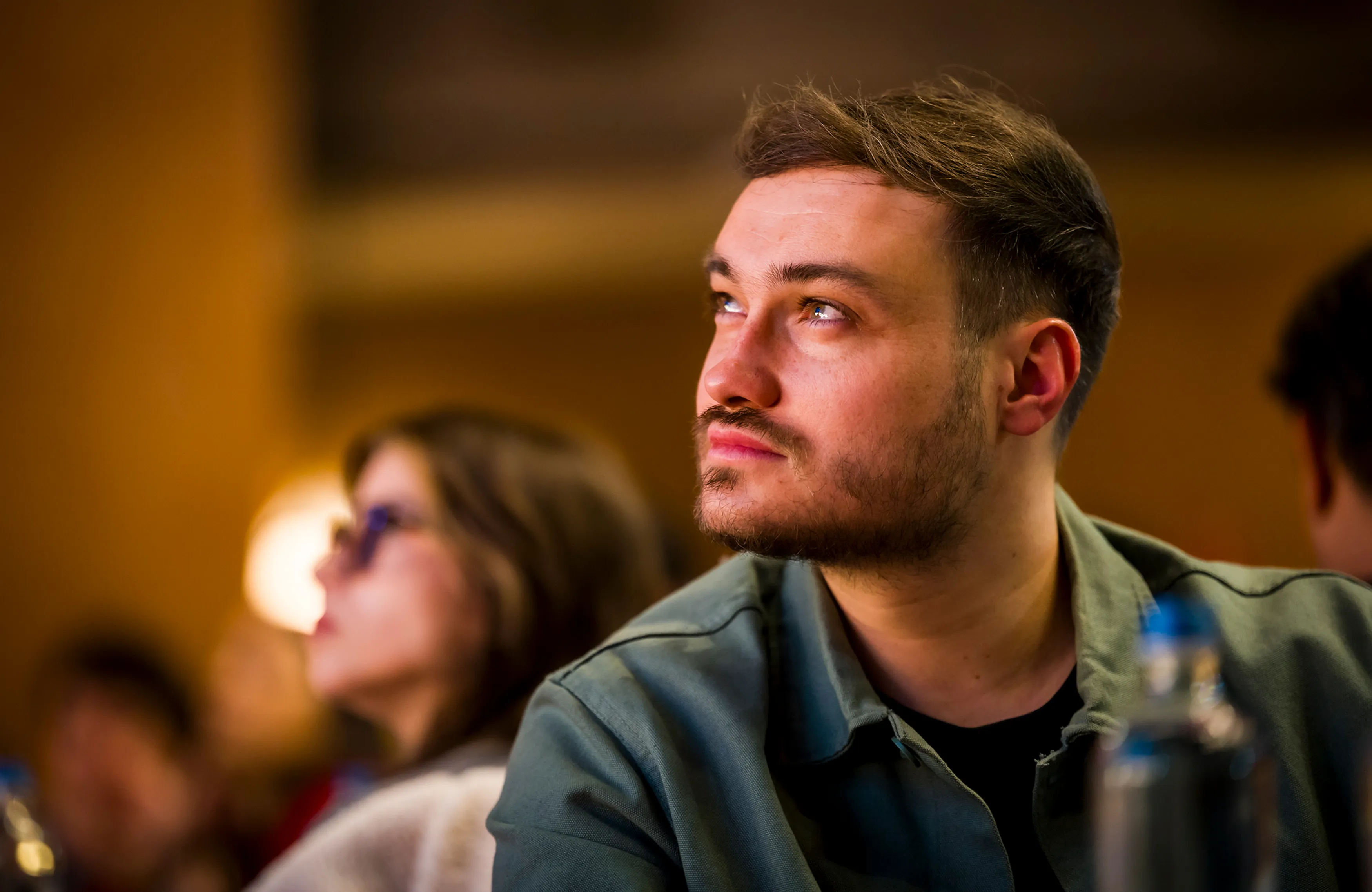 Portrait de profil d'un collaborateur du groupe Positive attentif lors d'une conférence d'entreprise.