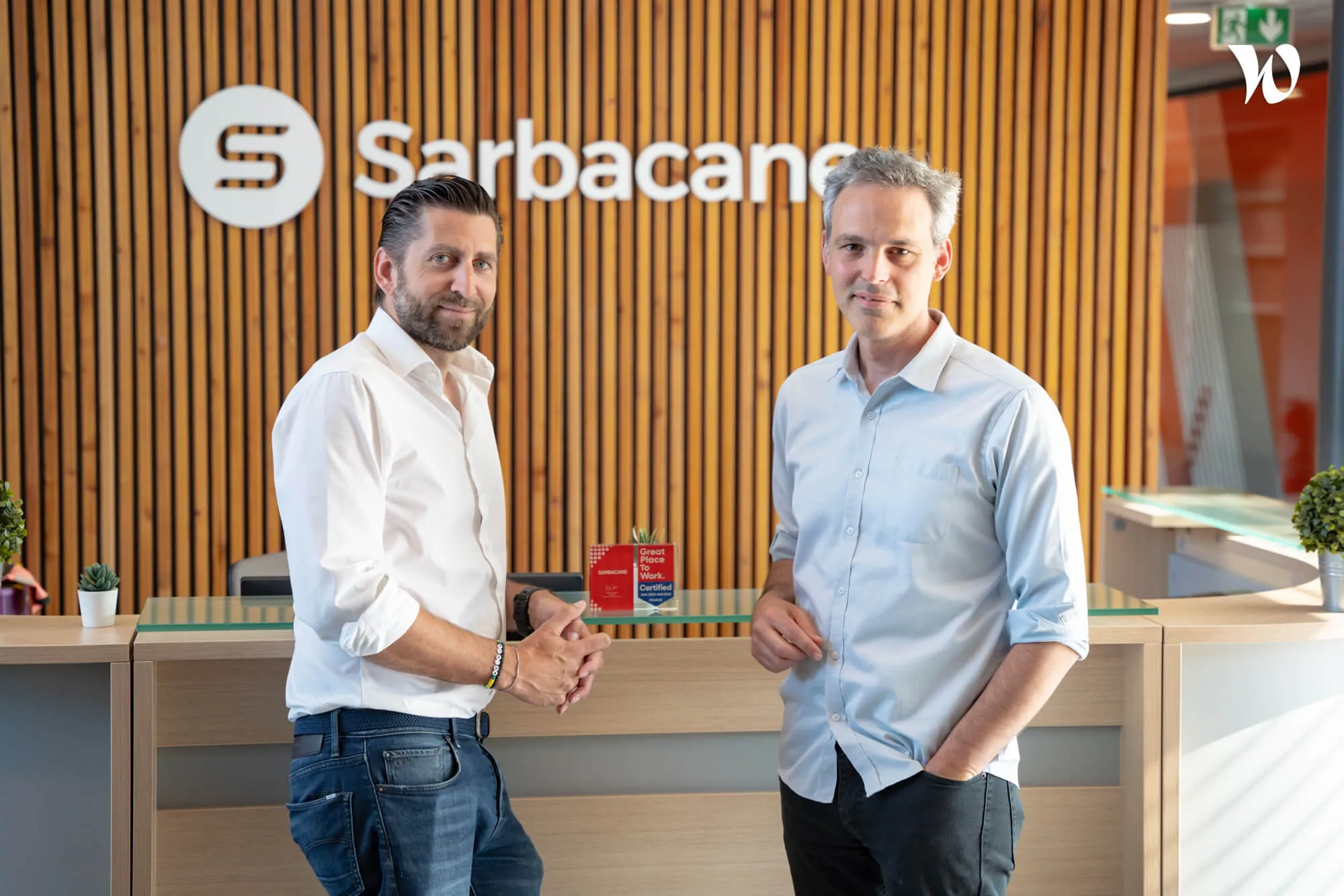 Mathieu Tarnus (fondateur et président) et Paul de Fombelle (CEO) devant le logo Sarbacane au siège du groupe Positive.
