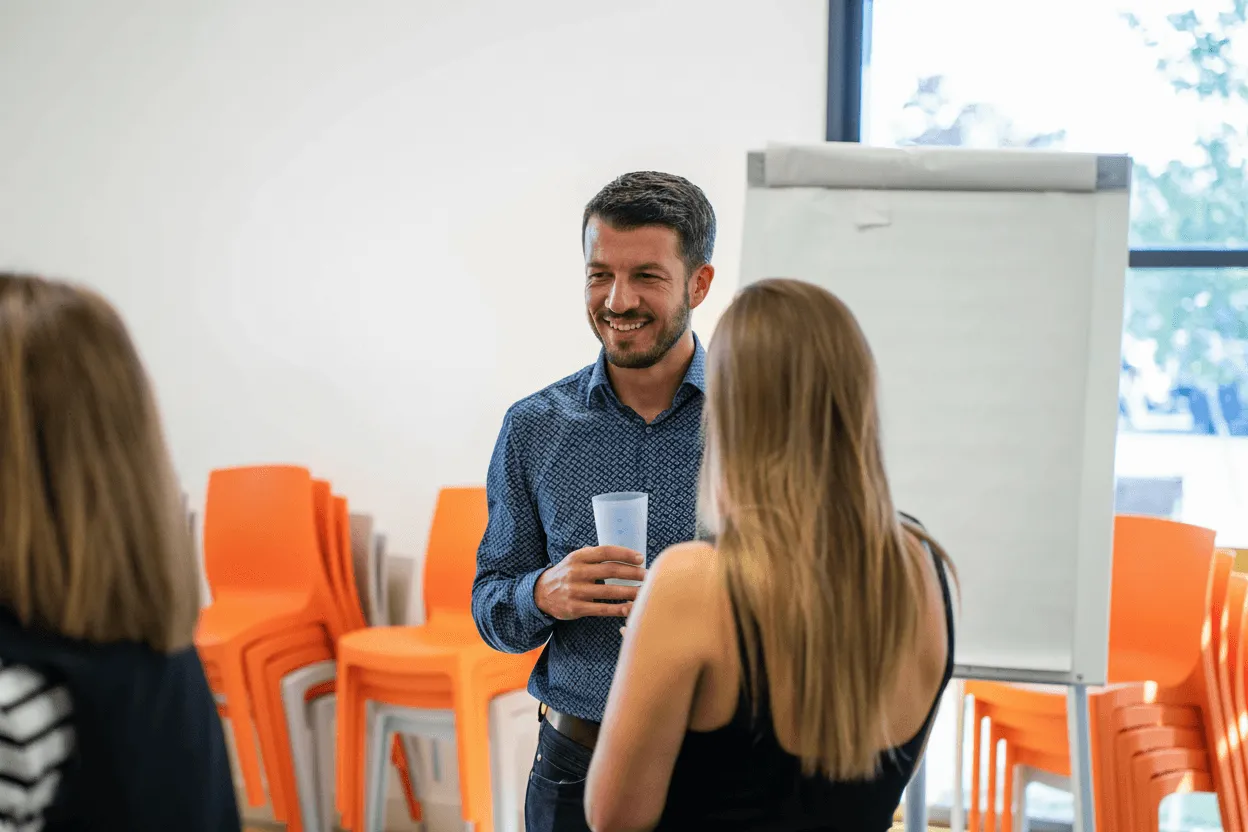 Collaborateurs de Positive échangeant de manière conviviale dans un espace de pause moderne et lumineux.