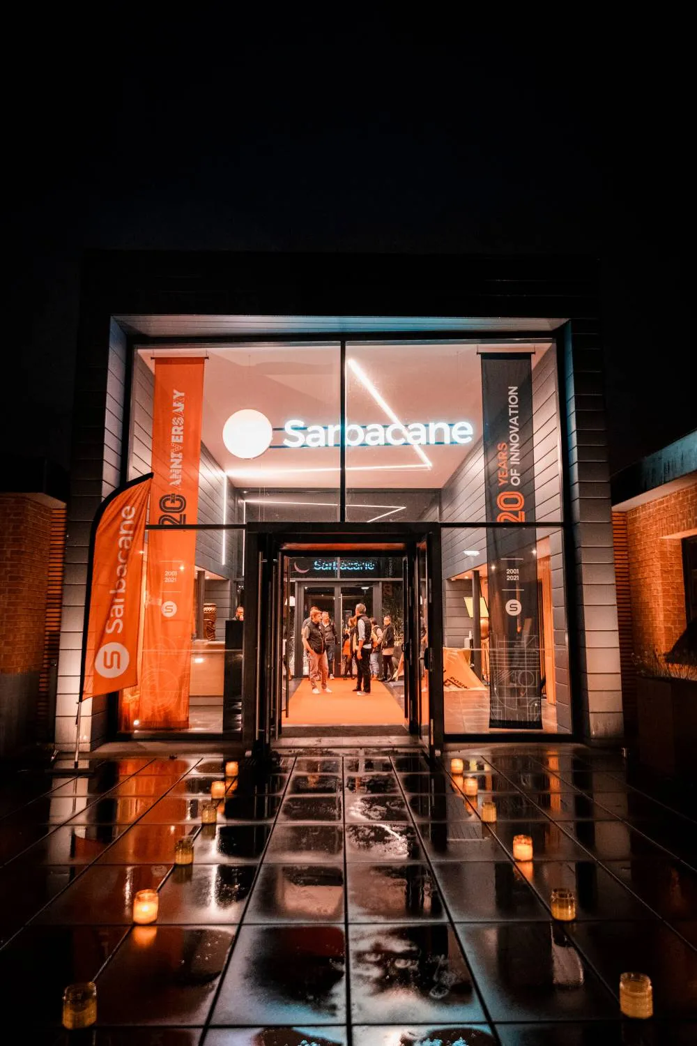Façade illuminée de nuit du bâtiment Sarbacane, siège du groupe Positive, célébrant 20 ans d'innovation.