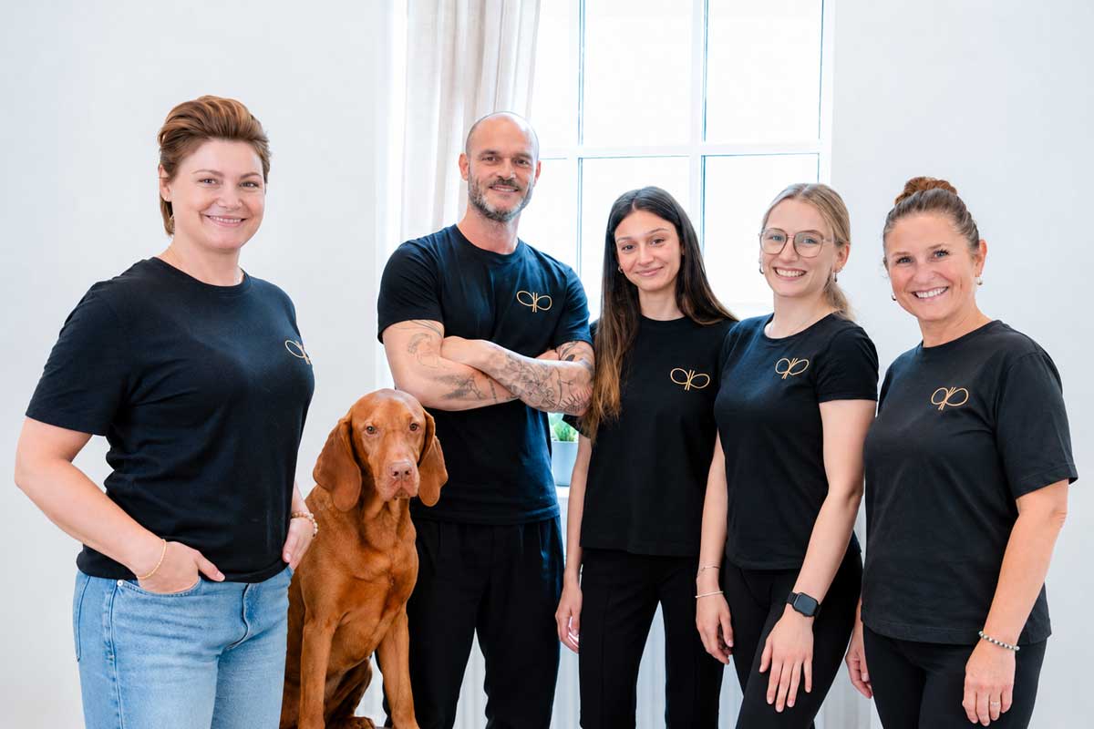 Team der Physiotherapie Pfitzner mit Hund vor weißem Hintergrund