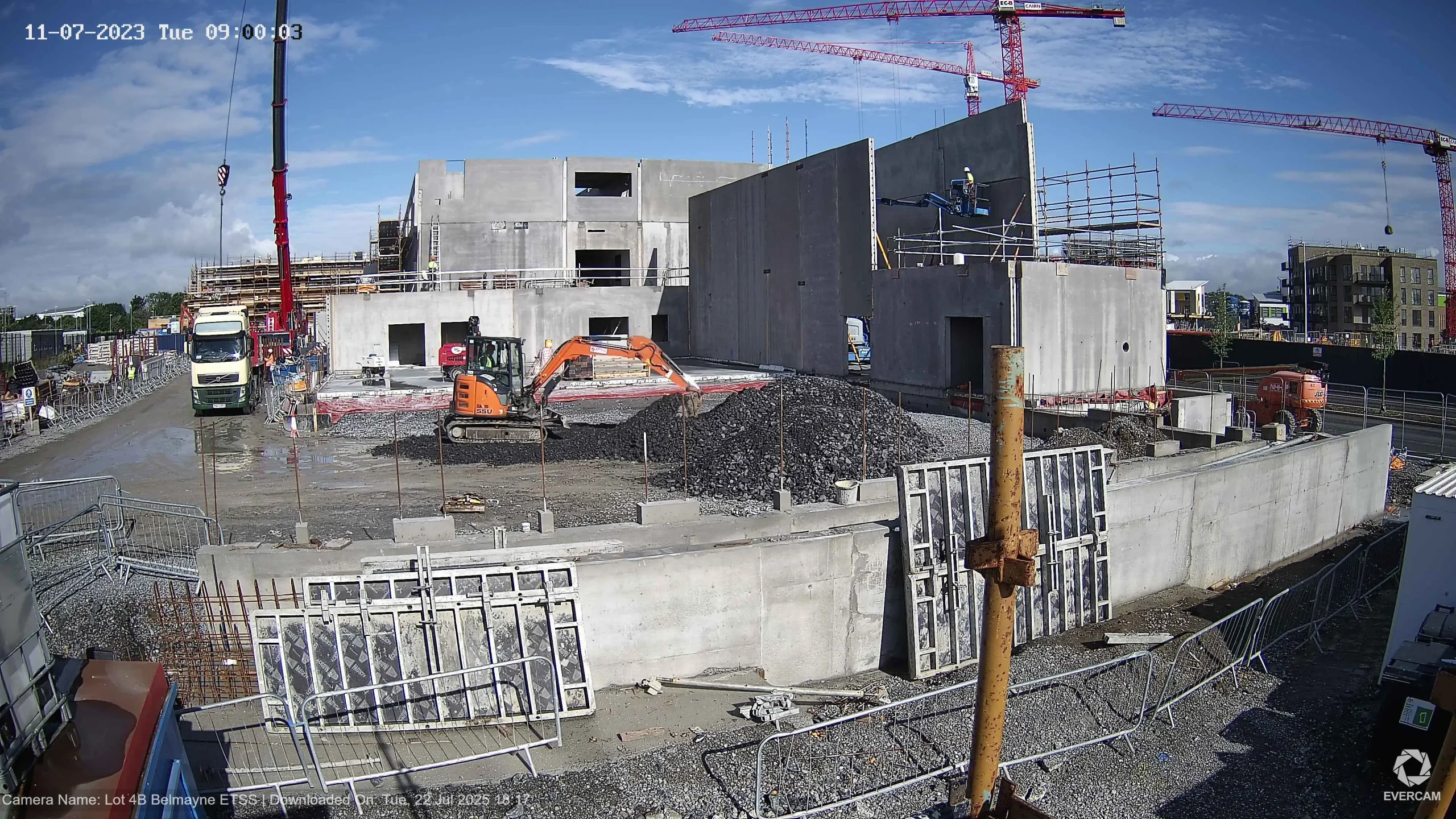 Wide-angle view of an active construction site in Dublin showing foundation works, cranes, and site activity.