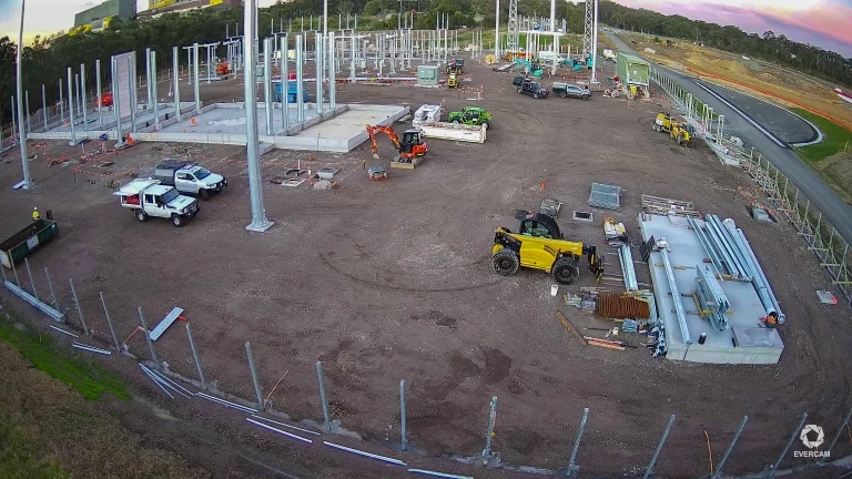 Wide-angle aerial view of a battery energy storage construction site with equipment, access roads, and work zones.