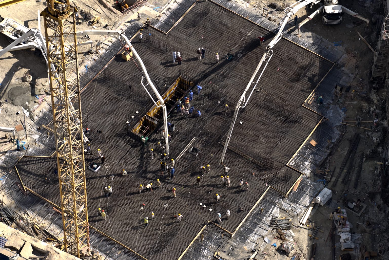 Overhead view of construction workers preparing and pouring concrete on a job site