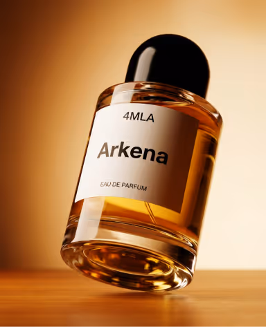 Close-up of a tilted perfume bottle labeled '4MLA Arkena Eau De Parfum' with amber-colored liquid inside, set against a warm-toned background.