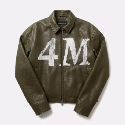 Dark green liquid soap dispenser bottle labeled 'FOURMULA' with a black pump and a leafy plant branch beside it.