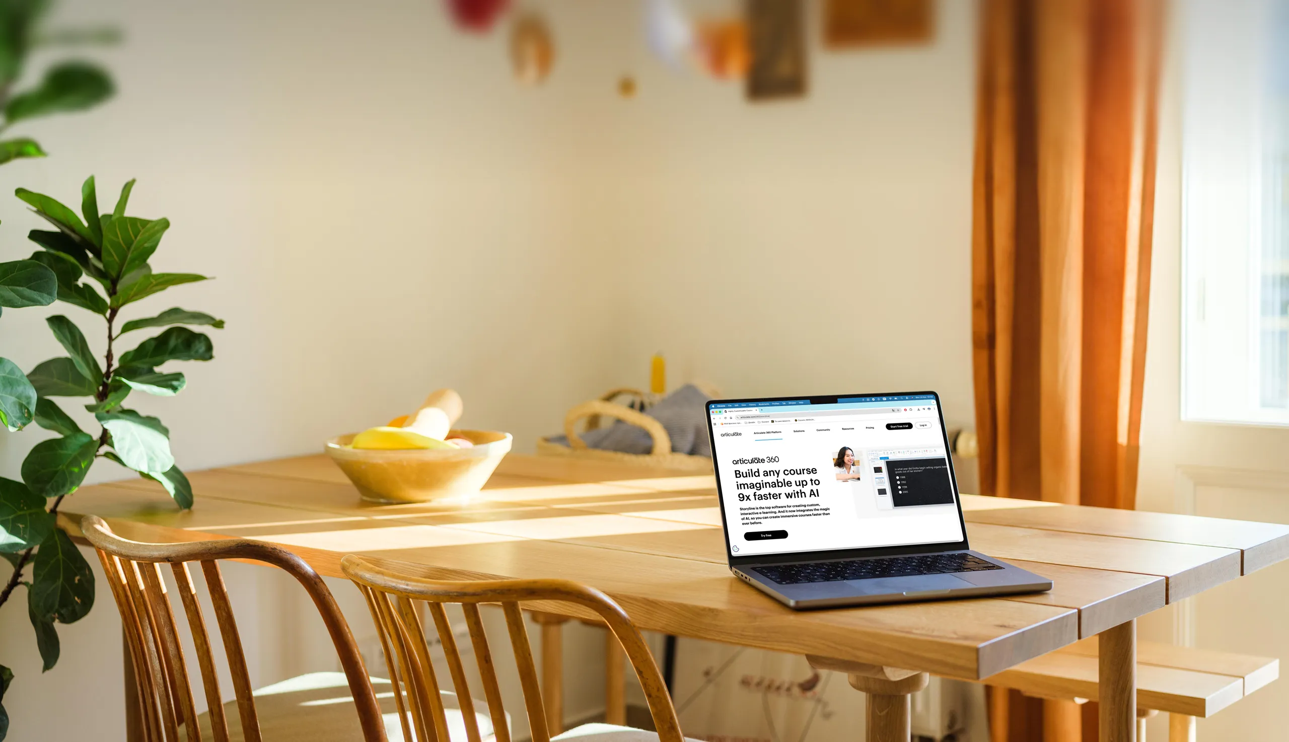 Wooden dining table with chairs, a bowl of fruit, a laptop displaying an educational website, and sunlight coming through a window with orange curtains.