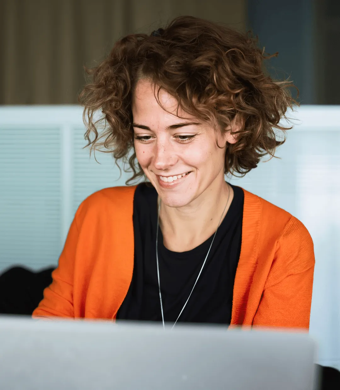 Business woman smiling, looking at laptop infront of her