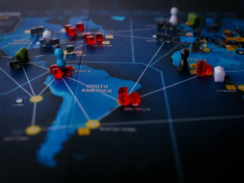 A clear incandescent light bulb placed on a black surface with a white chalk drawing of a thought bubble around it.