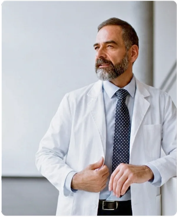 Concierge physician in a white coat standing in a bright consultation room