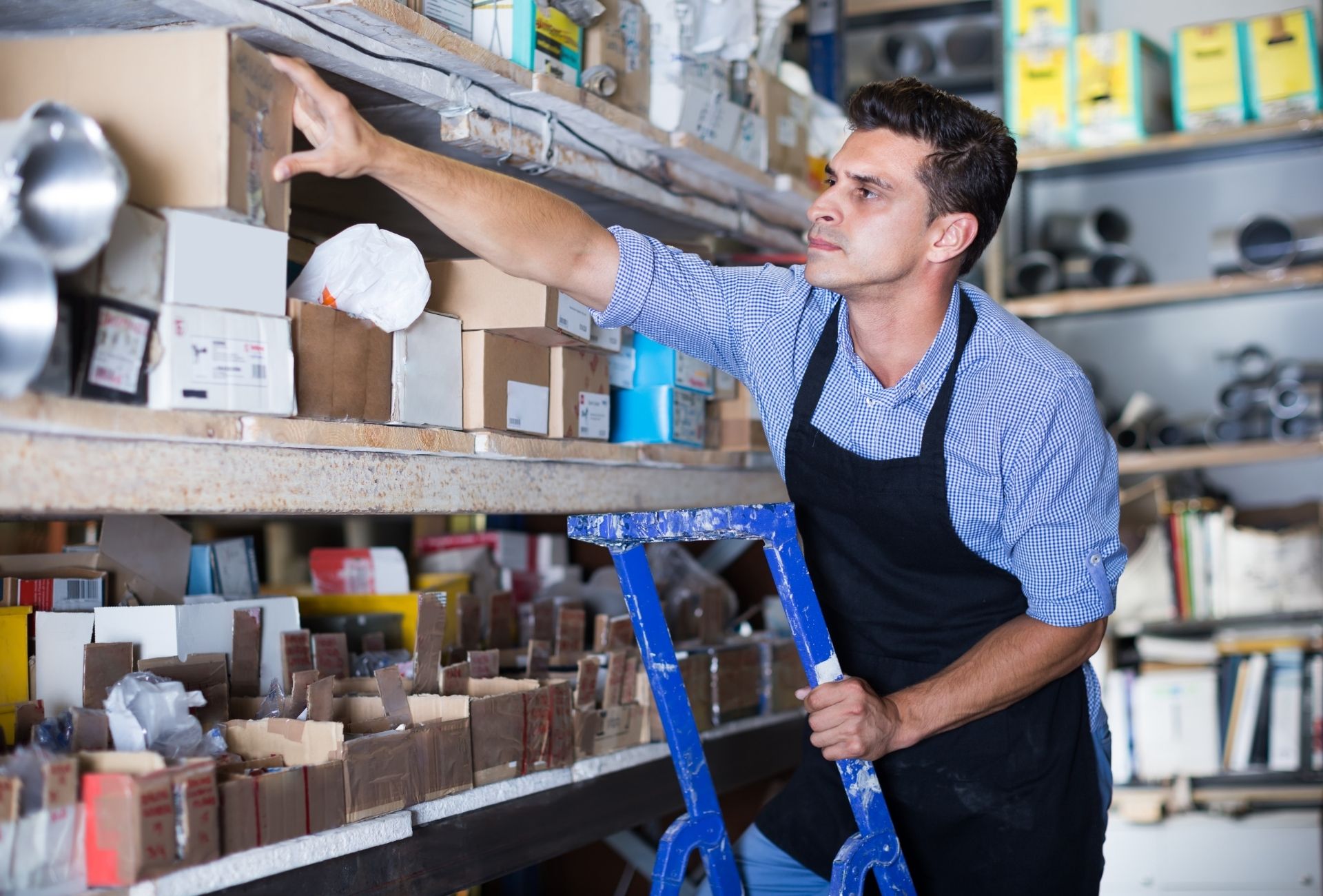 man on ladder restocking in a retail shop