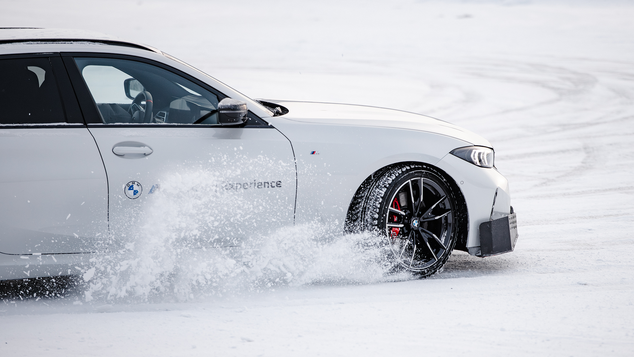 A BMW kicking up snow while driving on ice in Kall/Åre, Sweden