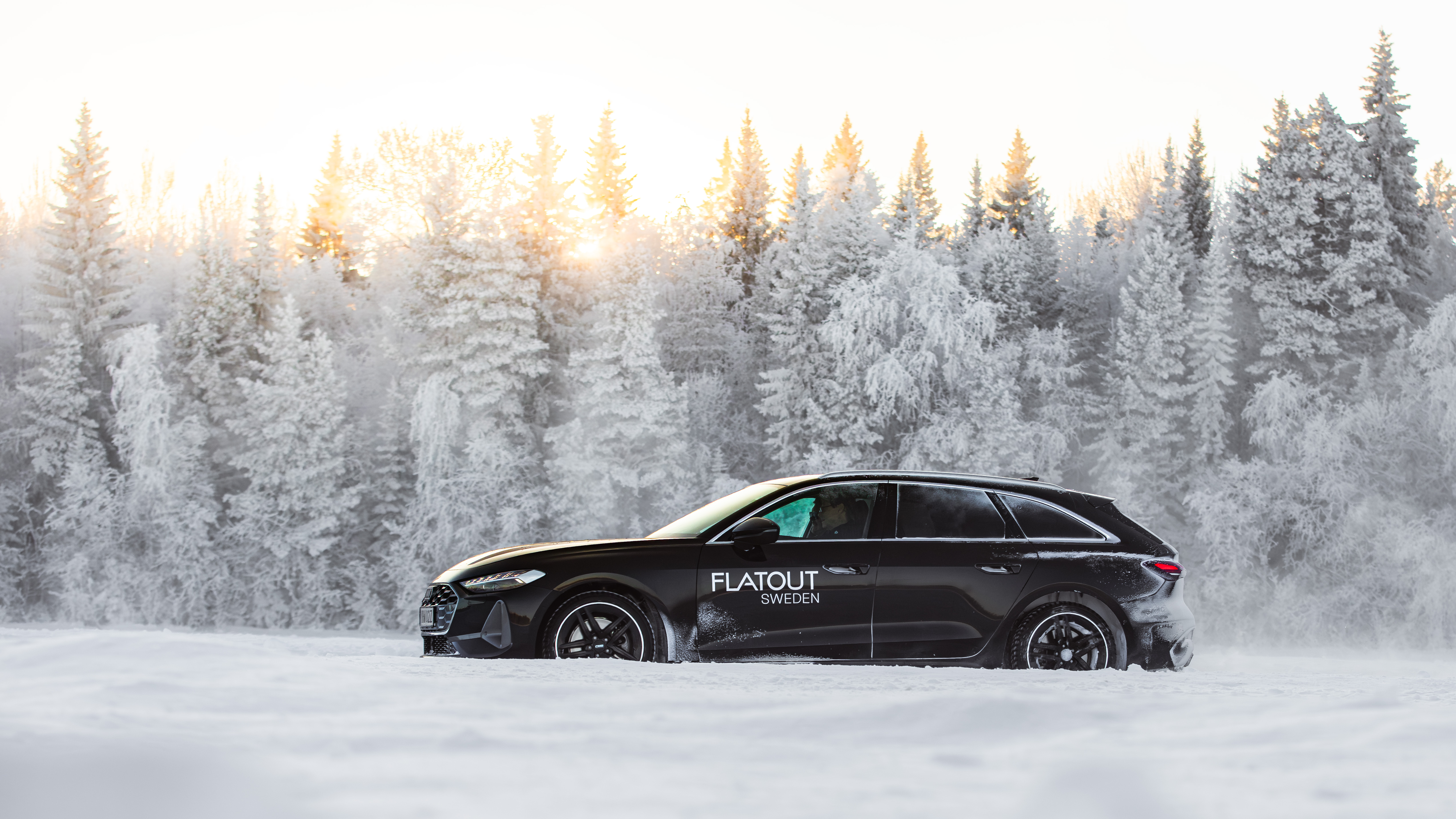 An Audi kicking up snow while driving on ice in Östersund, Sweden