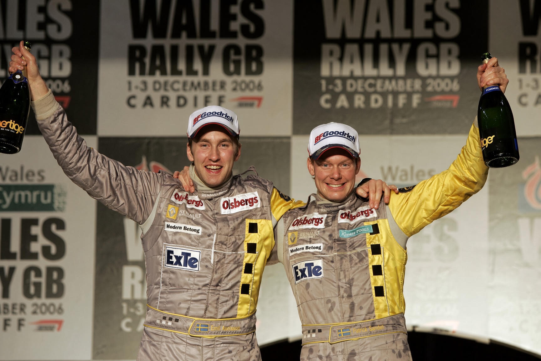 Patrik Sandell and Emil Axelsson celebrating with trophies on a rally podium