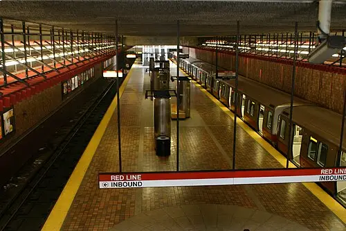 Alewife station Red Line subway platform with a train stopped on the right and empty tracks on the left.