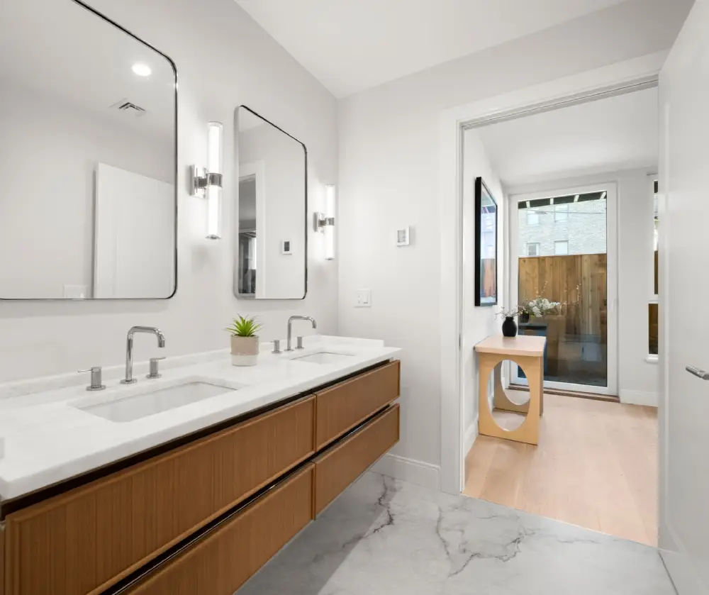 Modern bathroom with white marble countertop, dual rectangular sinks, wood cabinetry, and two large rectangular mirrors above.