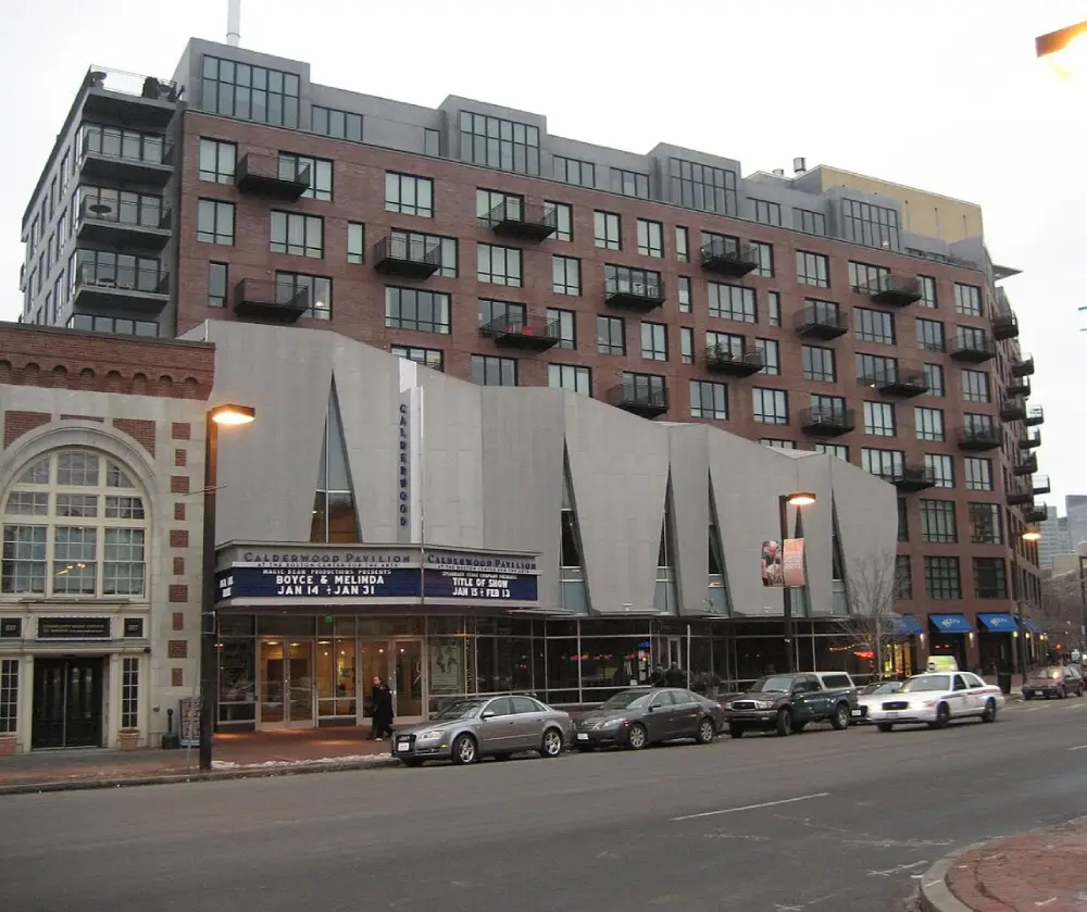 Street view of Calderwood Pavilion with theater marquee and adjacent residential building with balconies.