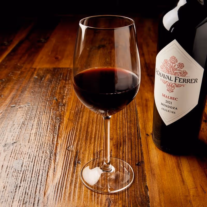 A glass and a bottle of red wine