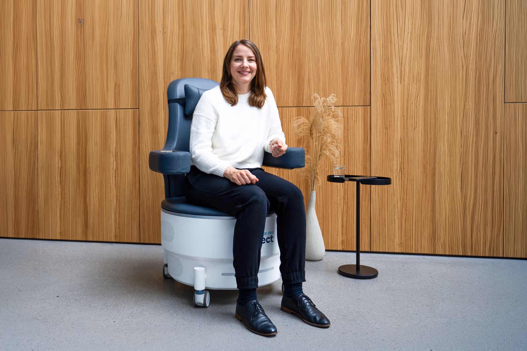 Beckenbodentraining mit dem EMP Chair Pro ONE in der Physiotherapie Pfitzner in Düsseldorf, Patientin sitzt entspannt auf dem Therapiesessel in einer modernen Praxis.