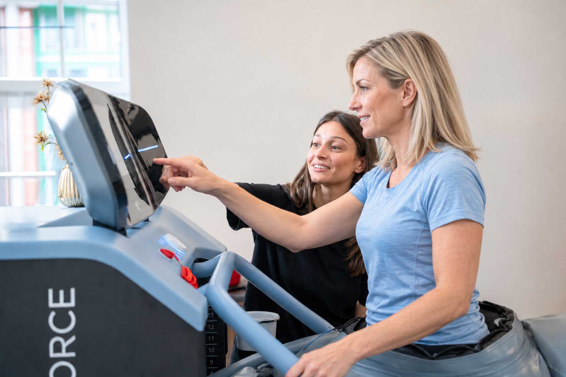 Patient beim entlasteten Gehtraining auf dem BTL Anti-Gravity Laufband in der Physiotherapie Pfitzner in Düsseldorf-Friedrichstadt, begleitet von einem Physiotherapeuten.