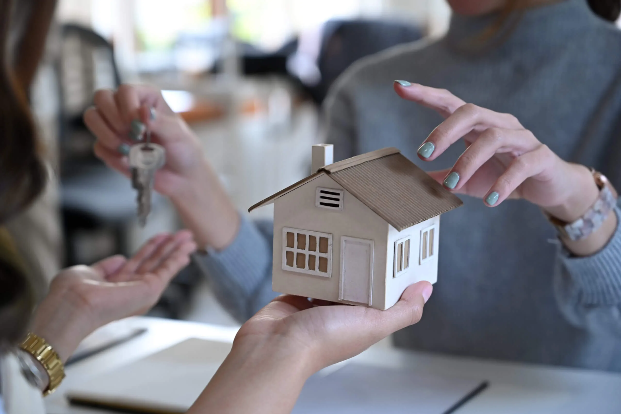 Lender and buyer holding keys and small house