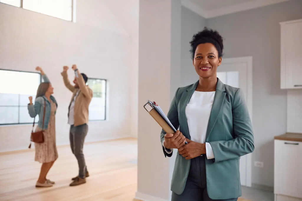 Smiling real estate agent and happy couple