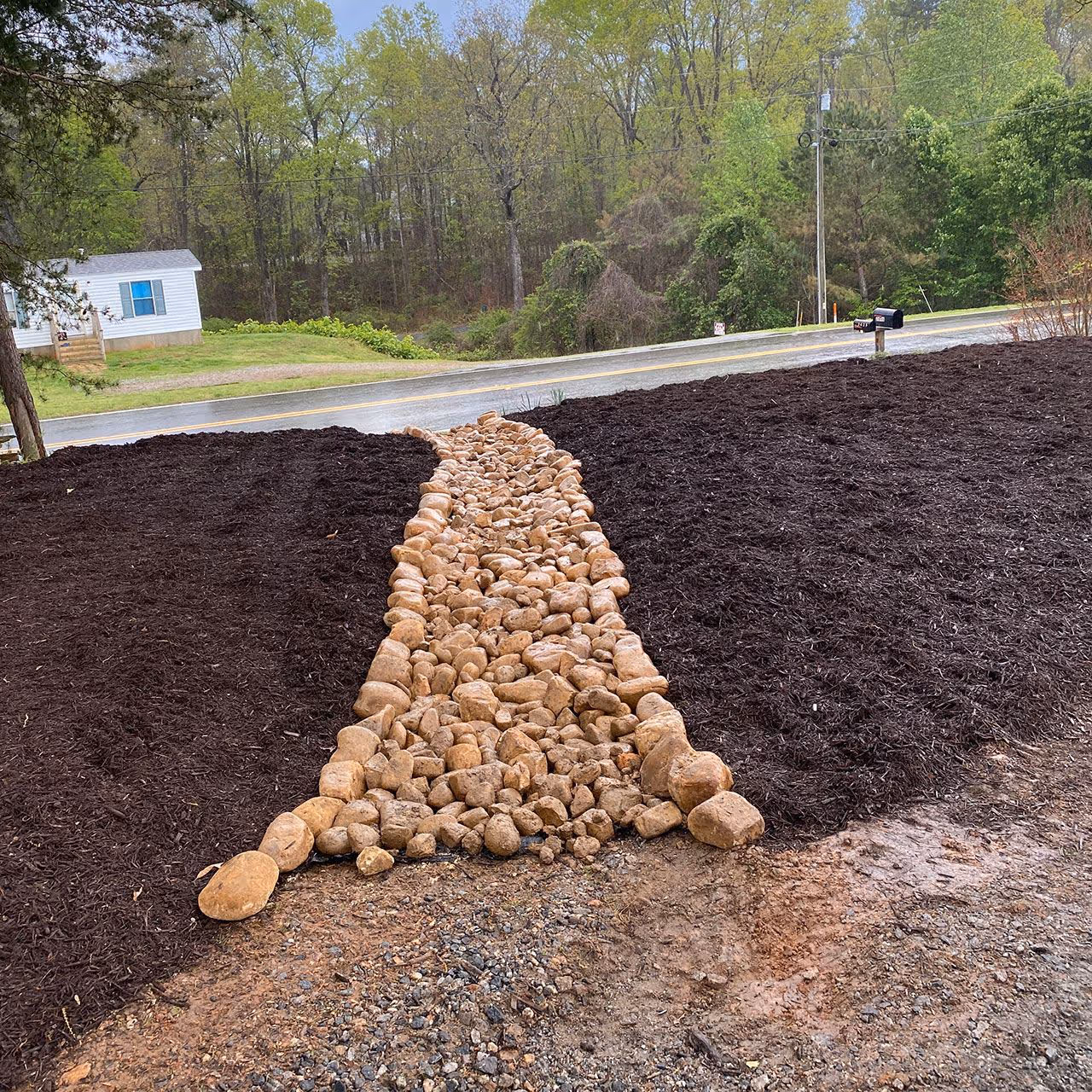 Decorative dry creek bed for drainage by Georgia Pro Scapes