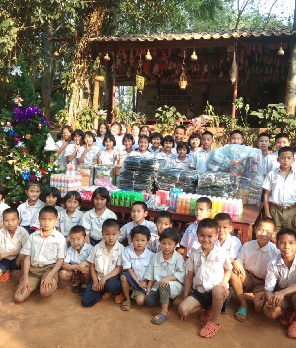 Group photo of children at a Thailand orphanage standing together outdoors.