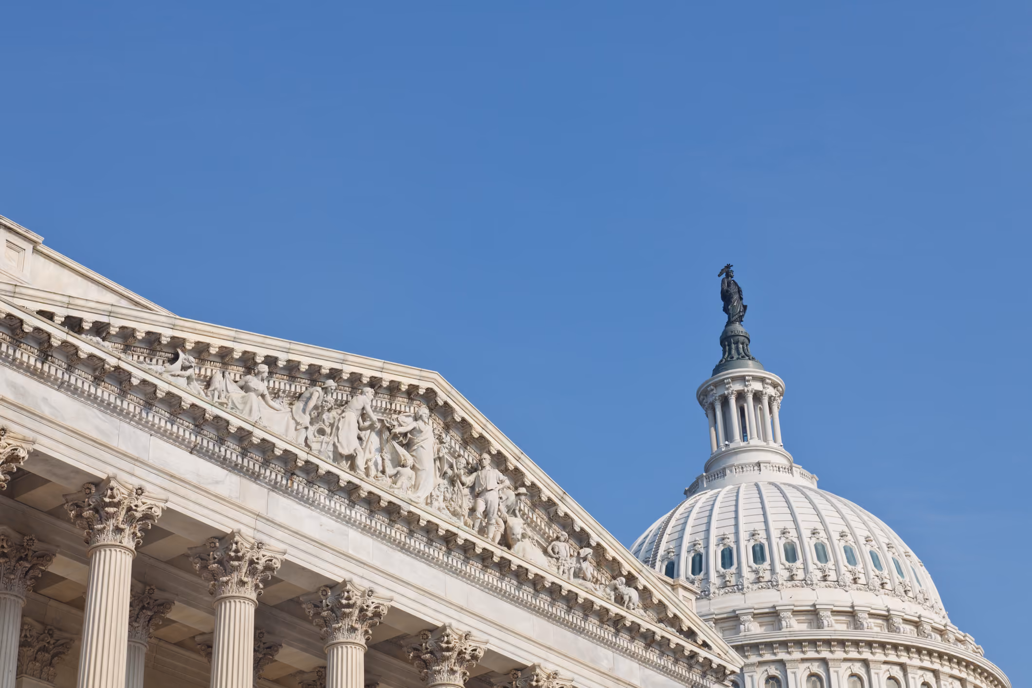 United States Capitol building facade and dome against a clear blue sky