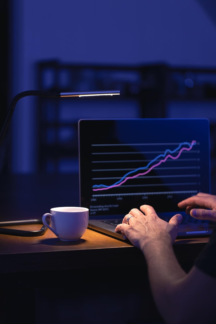 Broker looking at laptop analyzing stock market invest trading stocks graph