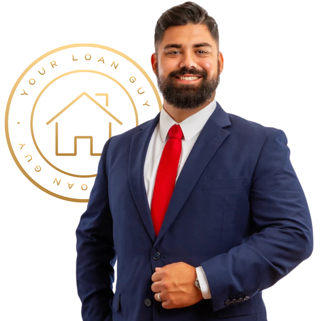 Smiling man with beard wearing a navy blue suit and red tie, posing against a plain light background.
