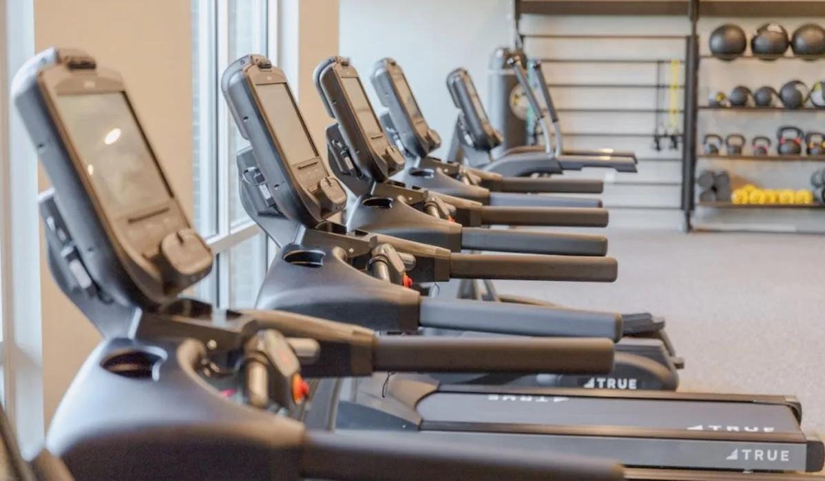 Treadmills lined up in the gym at Lofts at Hamilton, emphasizing a commitment to wellness and fitness.