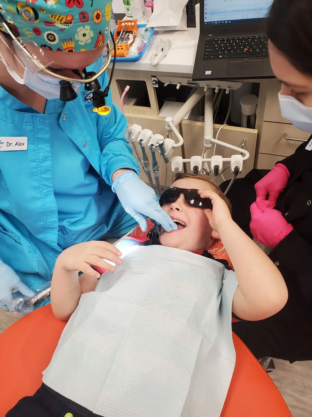 A young girl getting her teeth checked by a dentist.