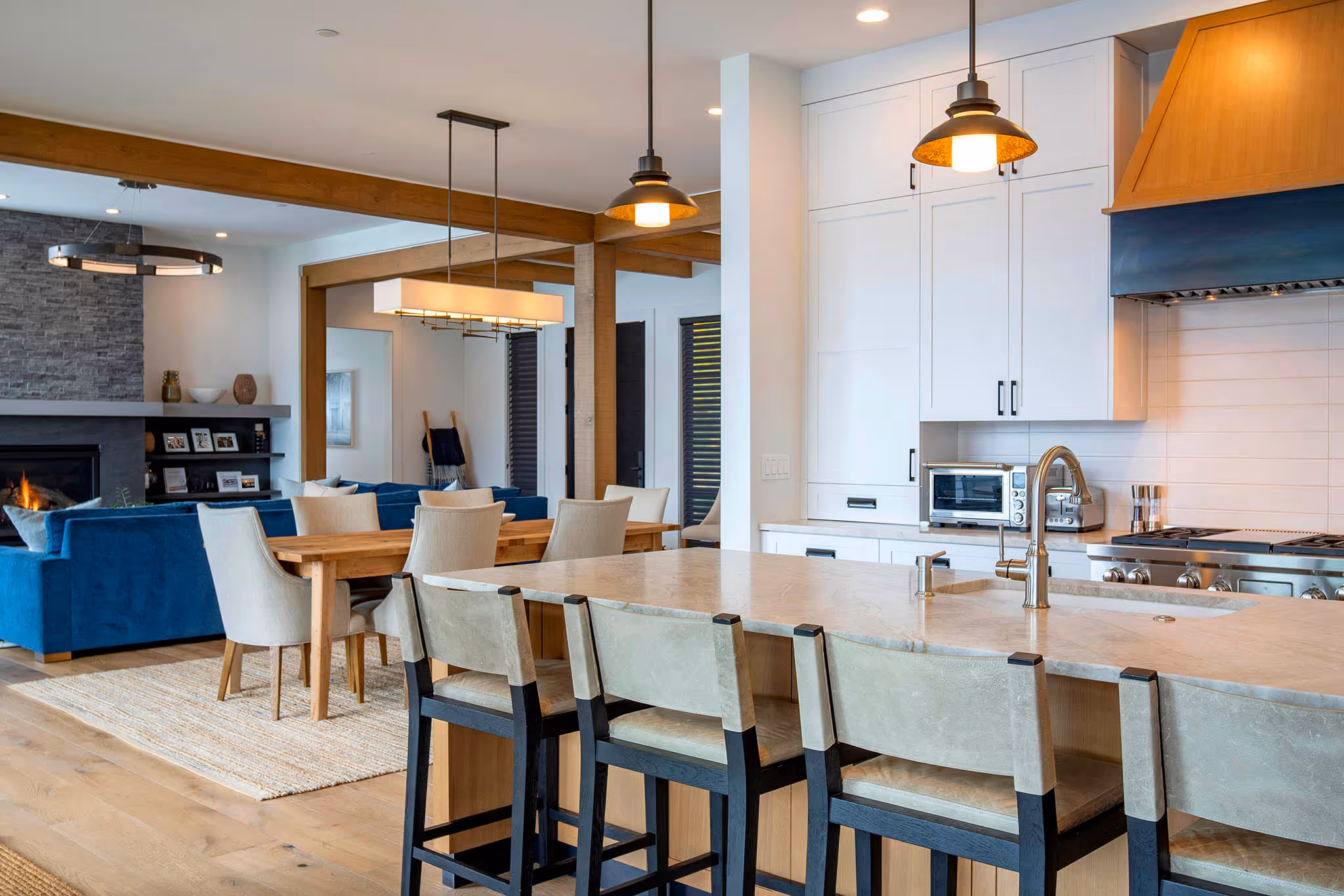 Modern bathroom vanity with light wood drawers, white marble countertop, round mirror, and brass faucet.