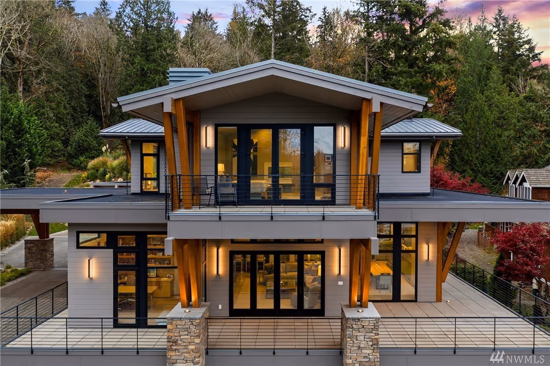 Modern bathroom vanity with light wood drawers, white marble countertop, round mirror, and brass faucet.