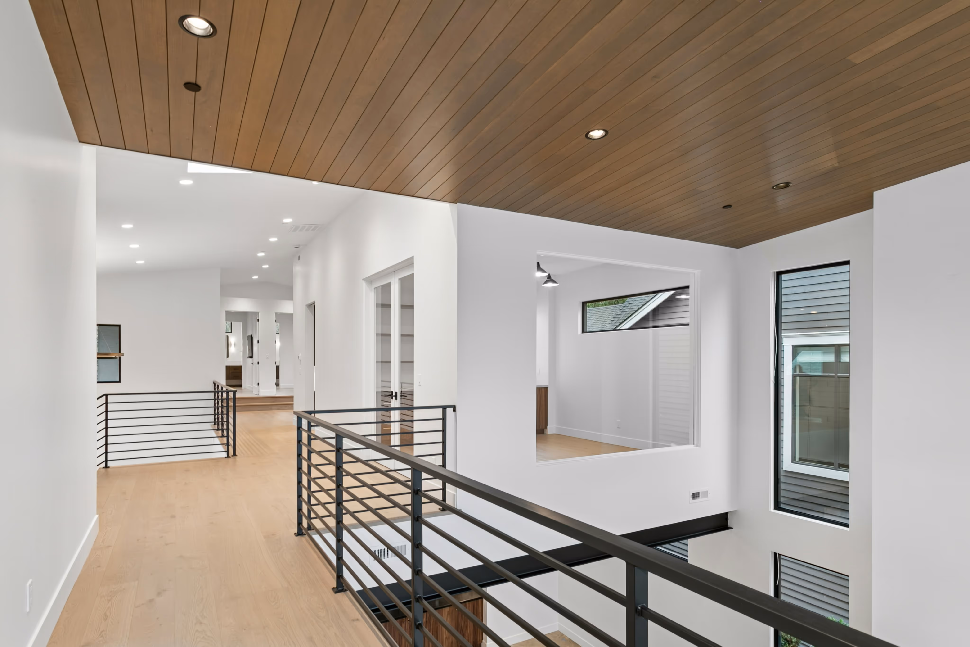 Modern bathroom vanity with light wood drawers, white marble countertop, round mirror, and brass faucet.