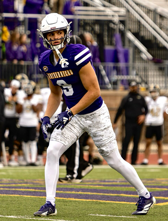 Football player in a purple and white uniform with number 6, on the field during a game.