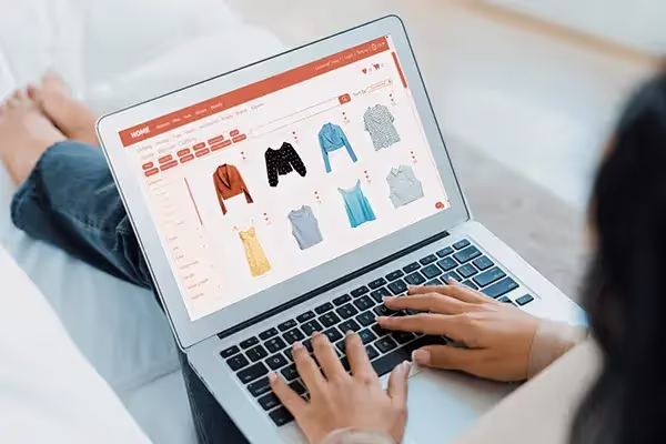 Une femme devant son pc occupée à faire un achat sur un site e-commerce.